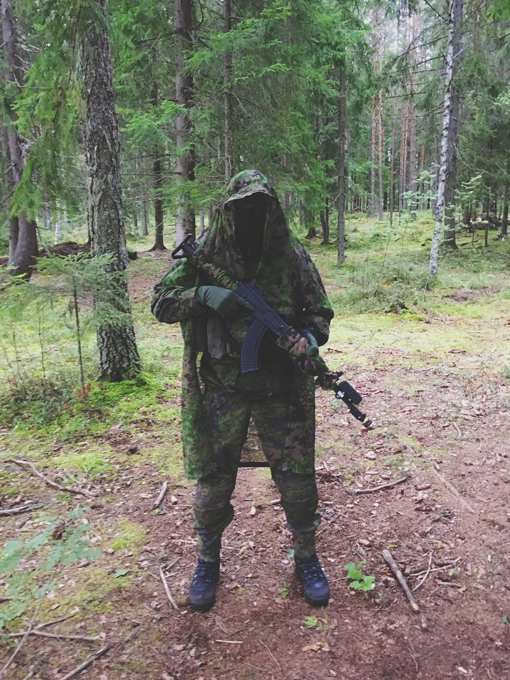 Sotilas varusteet päällä metsässä.