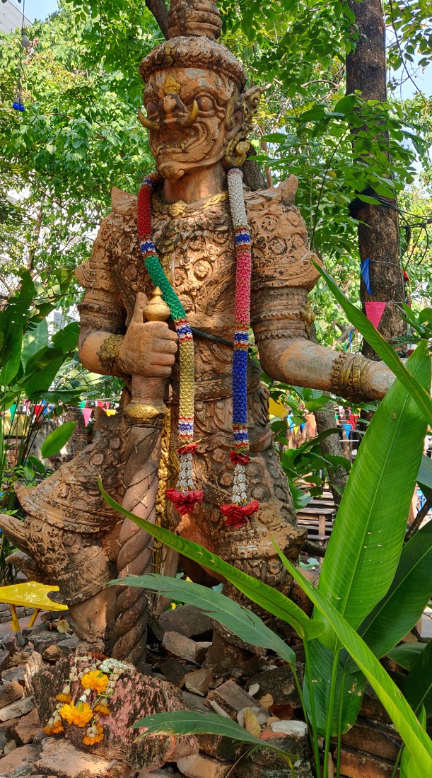 Iso torahampainen patsas, johon ripustettu kukkakoristeita.