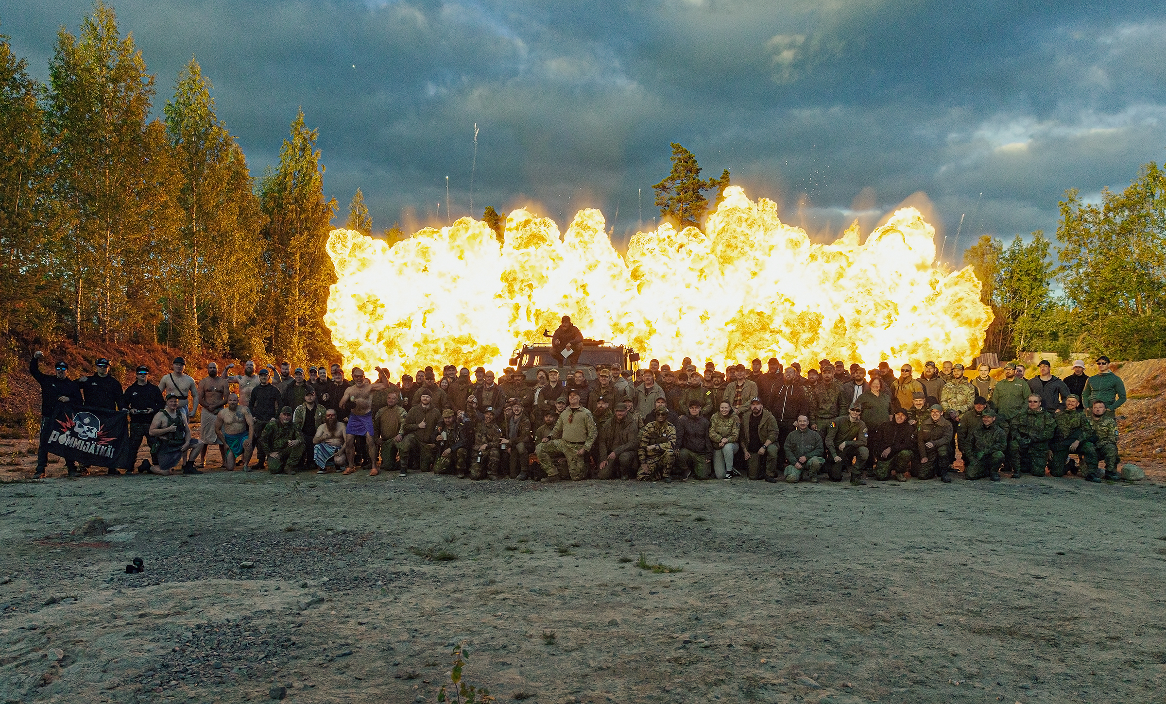 Participants in a row in front of a sea of flames.