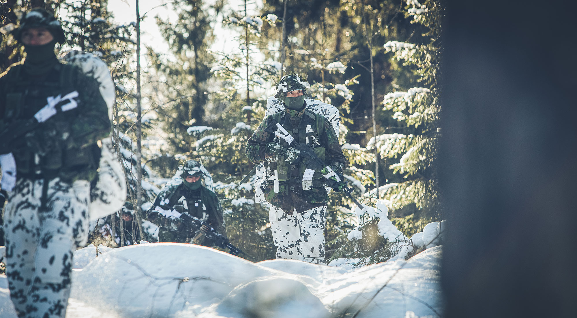 M05 pakkaskuvioitu yläosa yhdistettynä lumikuvioituun alaosaan sotilaita metsässä