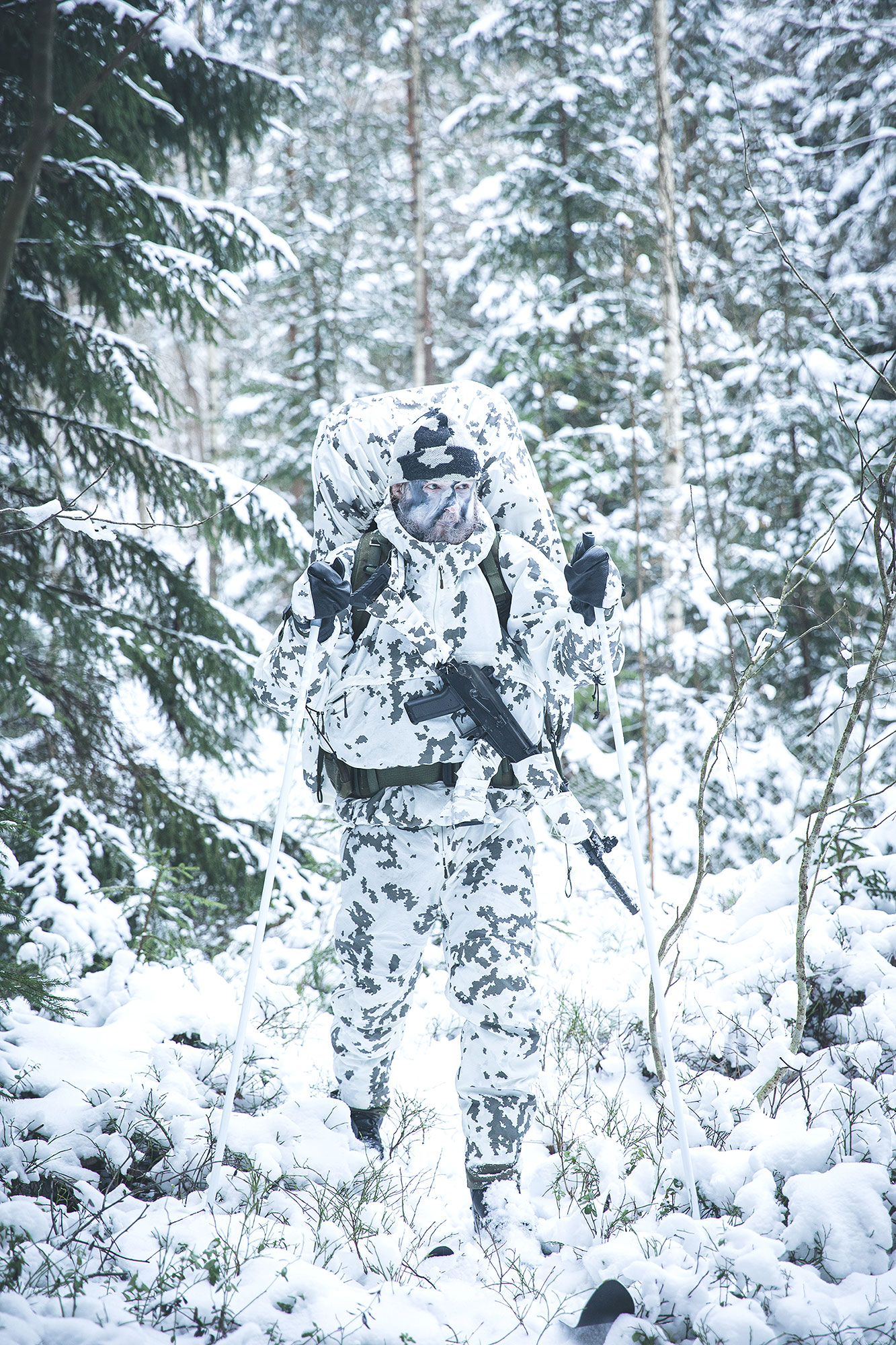 Täysin lumikuviotu sotilas hiihtämässä