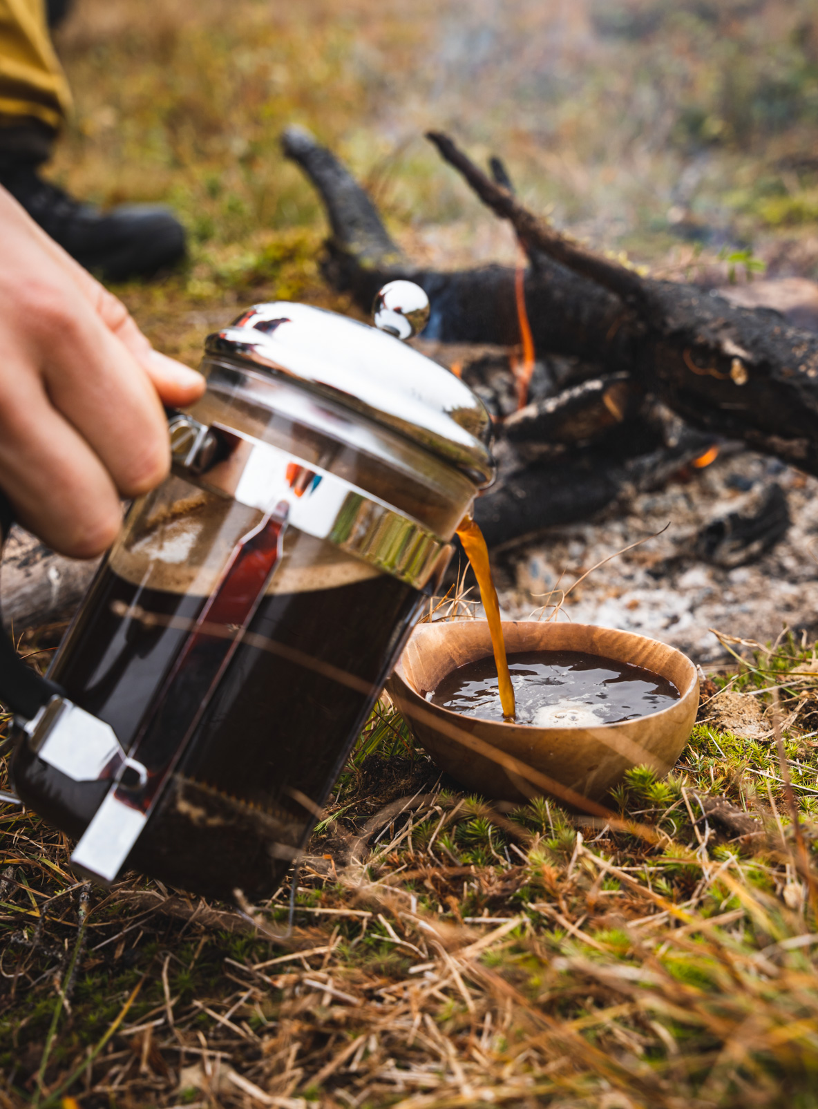 Pouring coffee in a kuksa in Lapland while moose hunting
