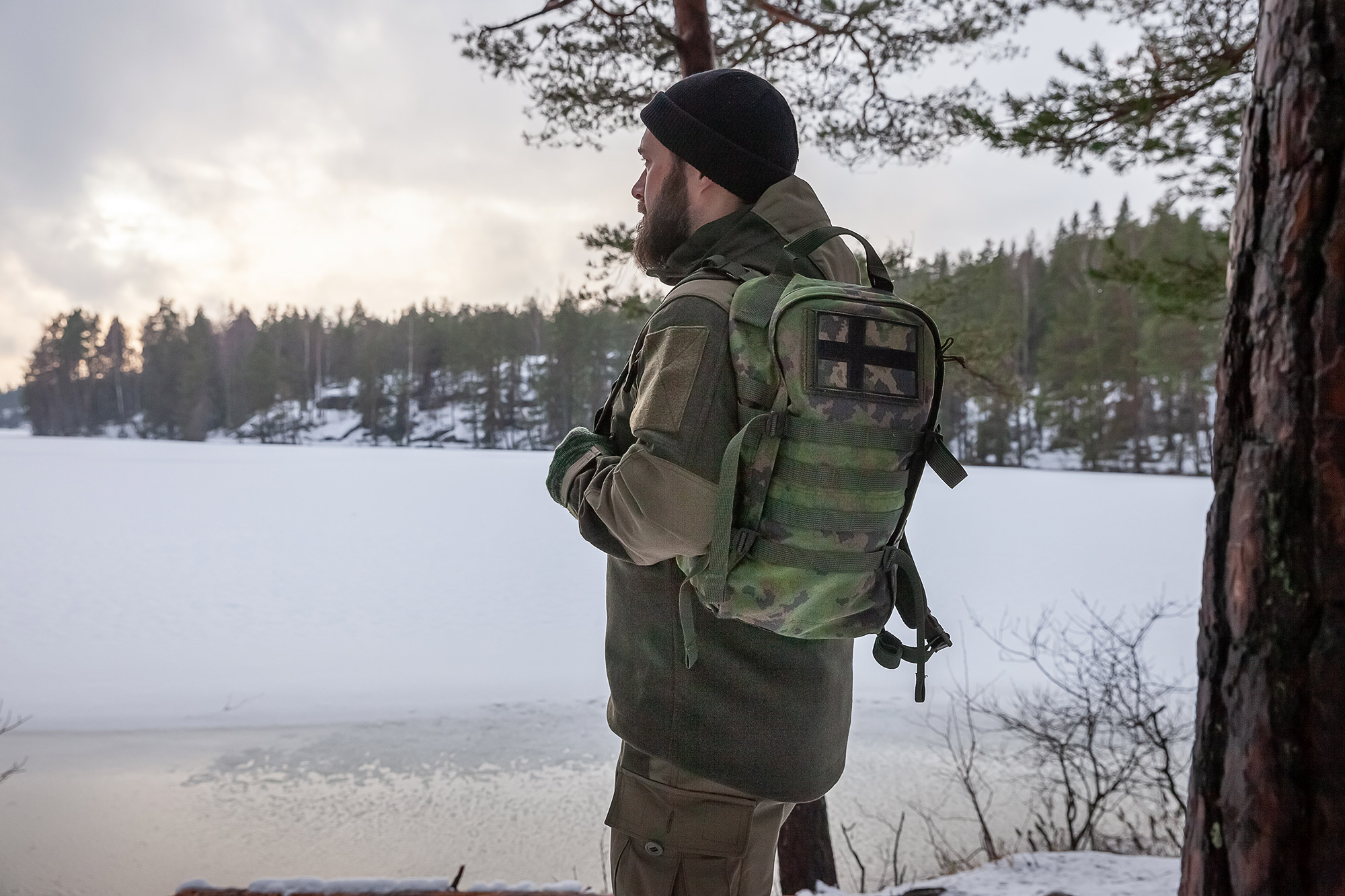 Man in the forest wearing the Varusteleka Särmä Woolshell outfit