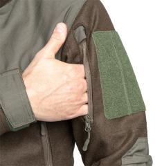 Särmä TST Woolshell-takki. Hihataskut vetoketjulla. Päällä tarramerkkipaikat.