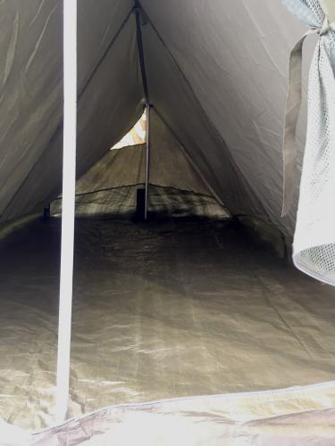 Belgialainen taistelijaparin teltta, palapelikuvioidulla päällisellä, ylijäämä. Harja laskee teltan perää kohti.