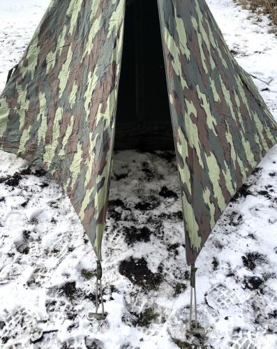 Belgialainen taistelijaparin teltta, palapelikuvioidulla päällisellä, ylijäämä. Oviaukko ja apsidi varusteita varten päädyssä.